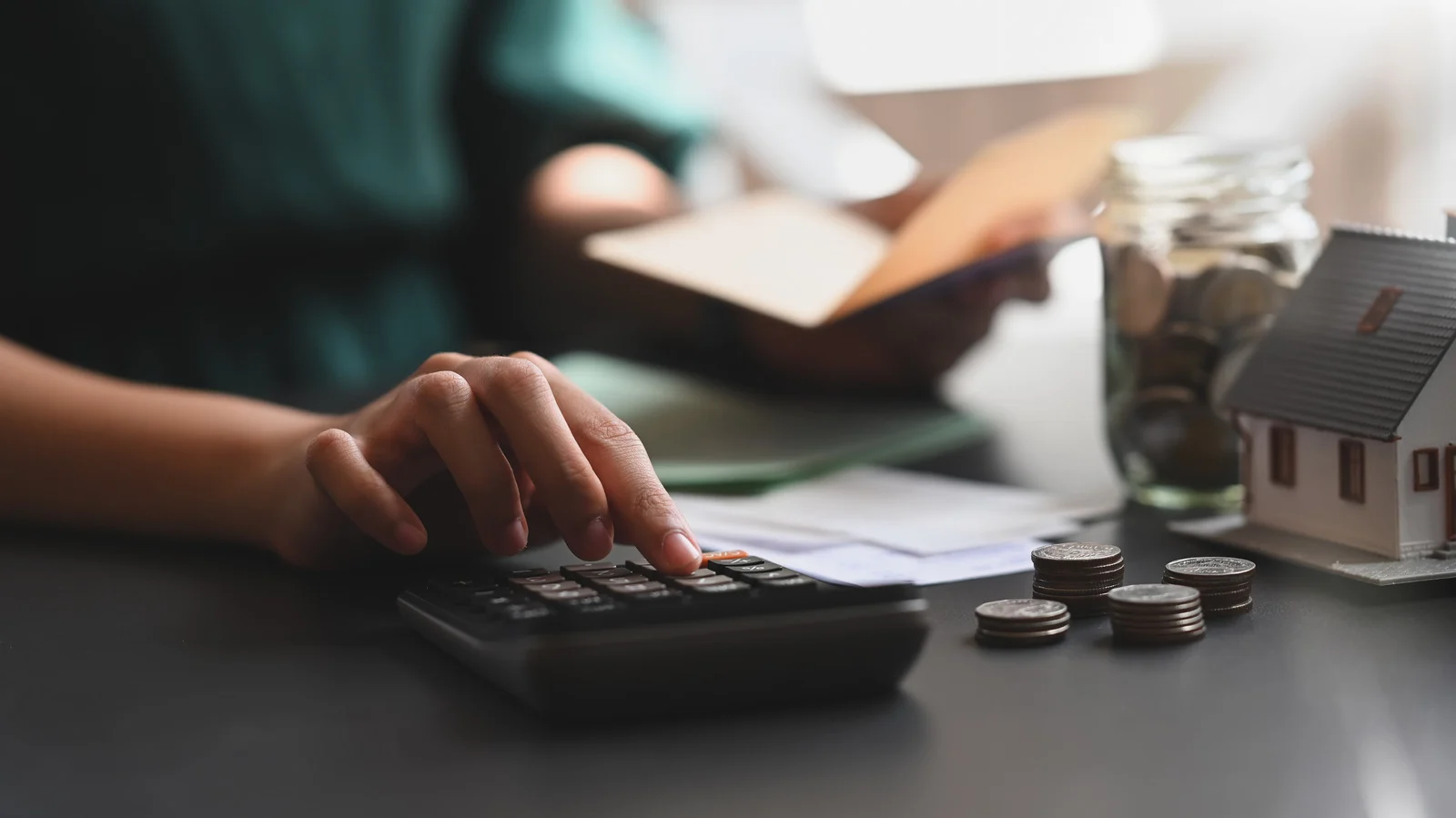 A calculator beside savings and a model home